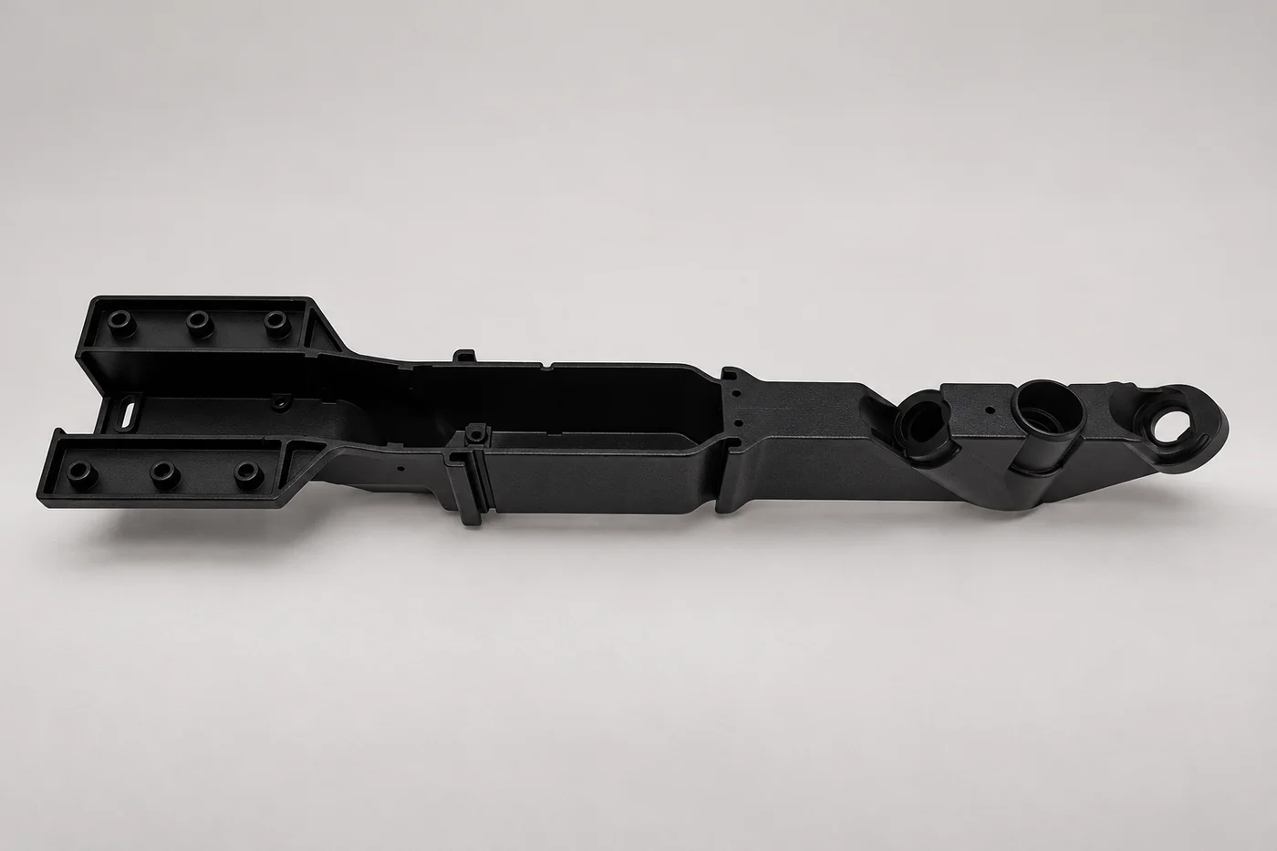 Long black prototype component with stepped geometry and attachment features