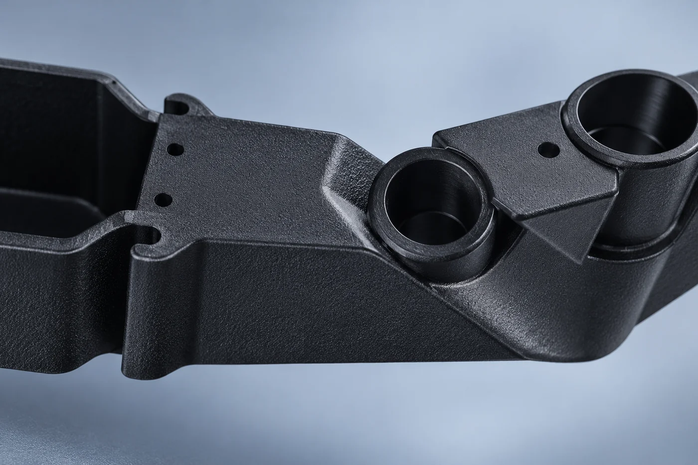 Close detail of a transition and mounting-hole region in a black prototype