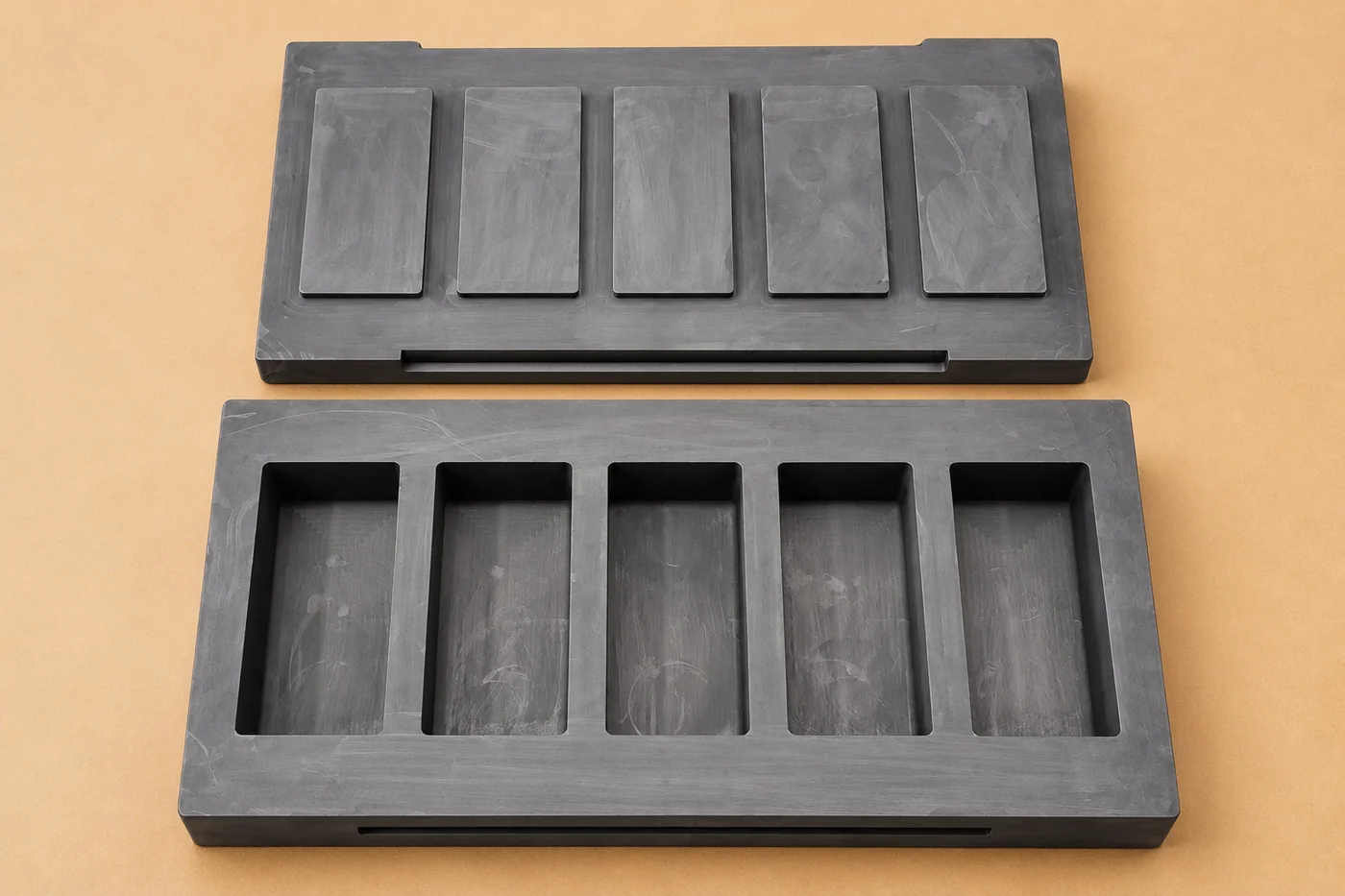 Top view of the graphite mould cavity and matching lid placed apart