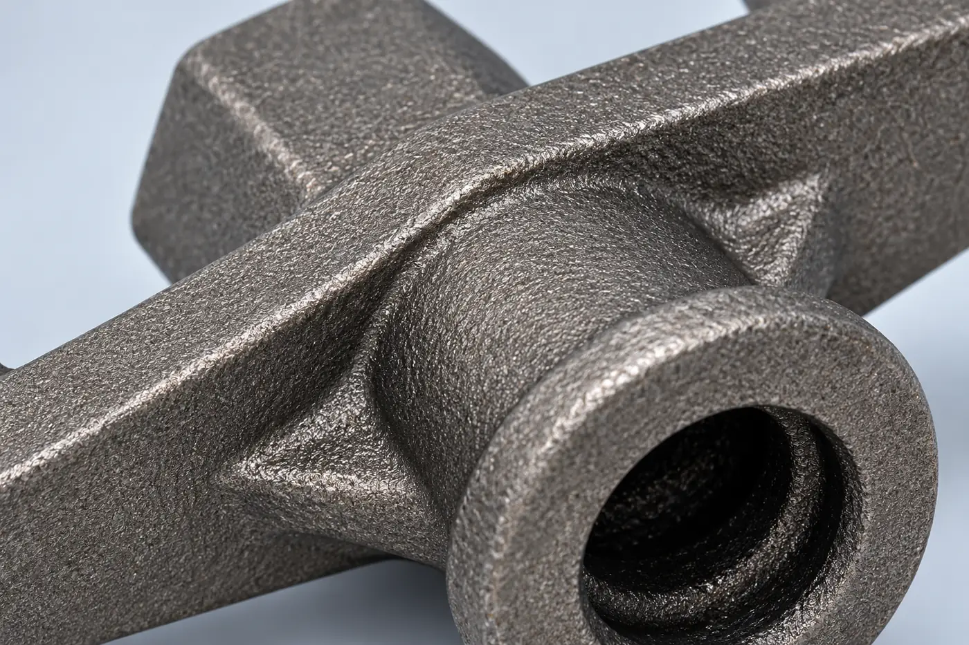 Close detail of a metal component bore and arm transition