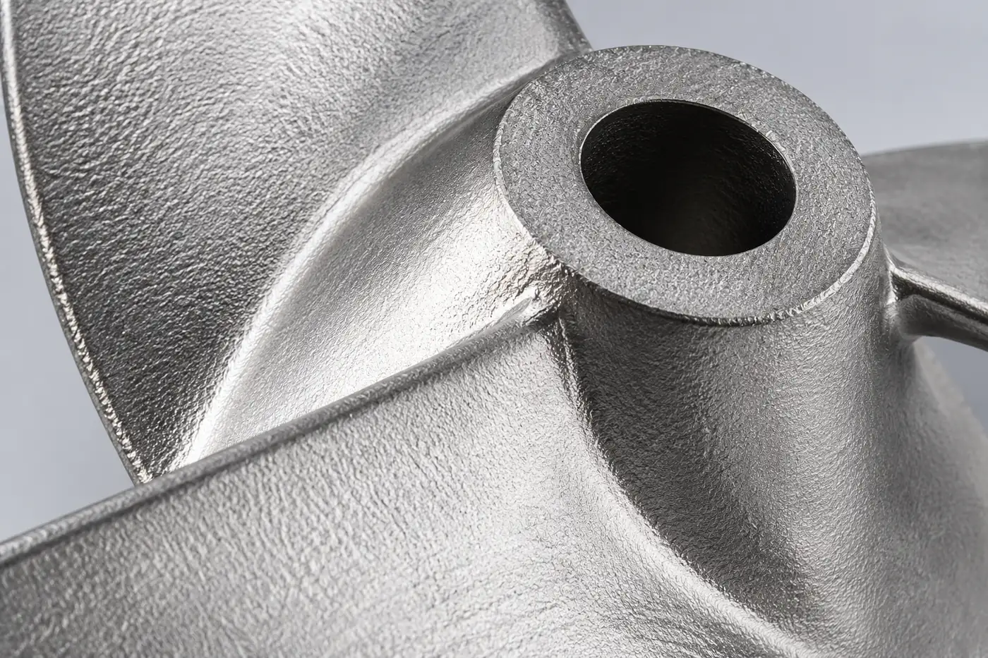 Close detail of a stainless impeller hub and blade-root geometry